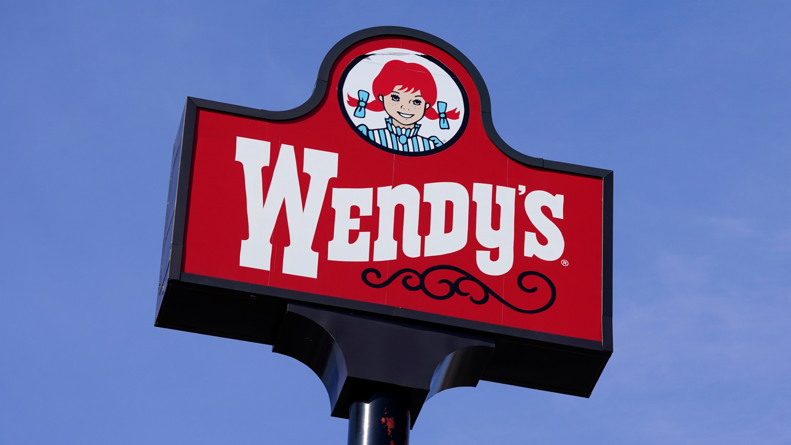 FILE - A sign stands over a Wendy's restaurant, Feb. 25, 2021, in Des Moines, Iowa. Food ads have long made their subjects look bigger, juicier and crispier than they are in person. But some consumers say those mouthwatering ads can cross the line into deception, and that’s leading to a growing number of lawsuits. Burger King is the latest company in the crosshairs. While the case against Burger King was filed in Miami, one of the attorneys who filed it has similar cases pending in New York against Wendy’s, McDonald’s and Taco Bell. (AP Photo/Charlie Neibergall, File)