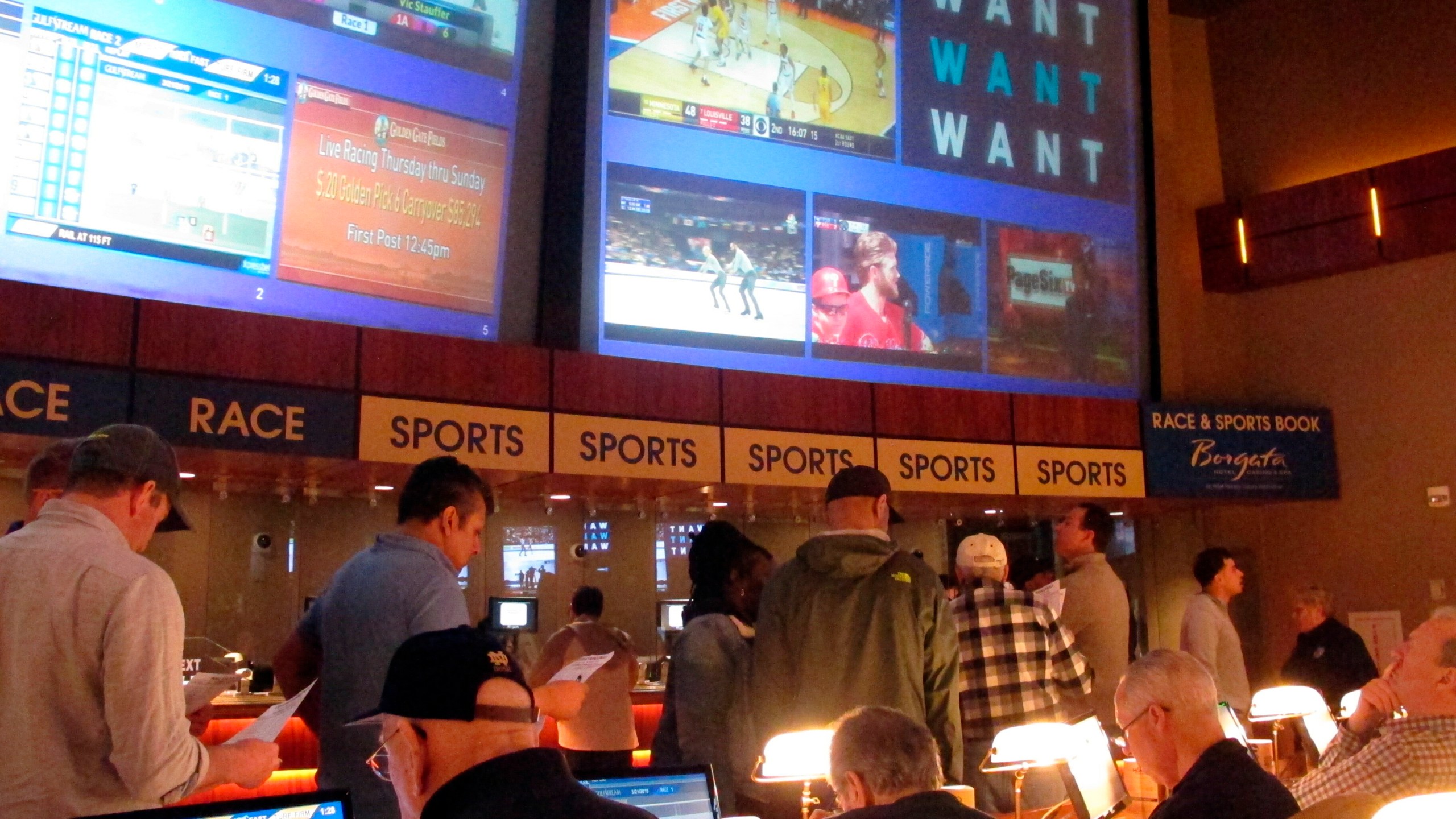 FILE - Gamblers line up to place bets on the NCAA men's college basketball tournament at the Borgata casino in Atlantic City N.J., March 21, 2019. When the NFL season kicks off, Kentucky residents will be able to legally bet on games for the first time. When they do, they also will be funding the state's first-ever program for people with gambling problems. (AP Photo/Wayne Parry, File)