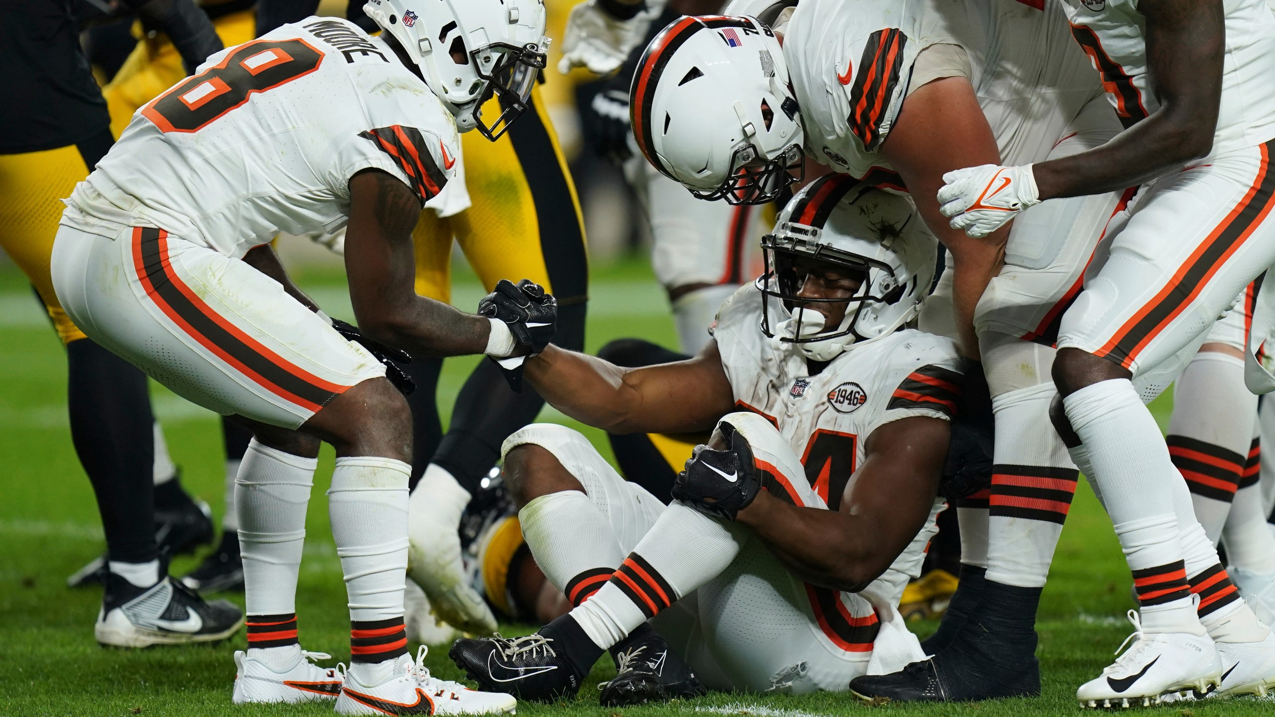 Cleveland Browns running back Nick Chubb, center, is helped up by teammates after an injury during the first half of an NFL football game against the Pittsburgh Steelers Monday, Sept. 18, 2023, in Pittsburgh. (AP Photo/Matt Freed)