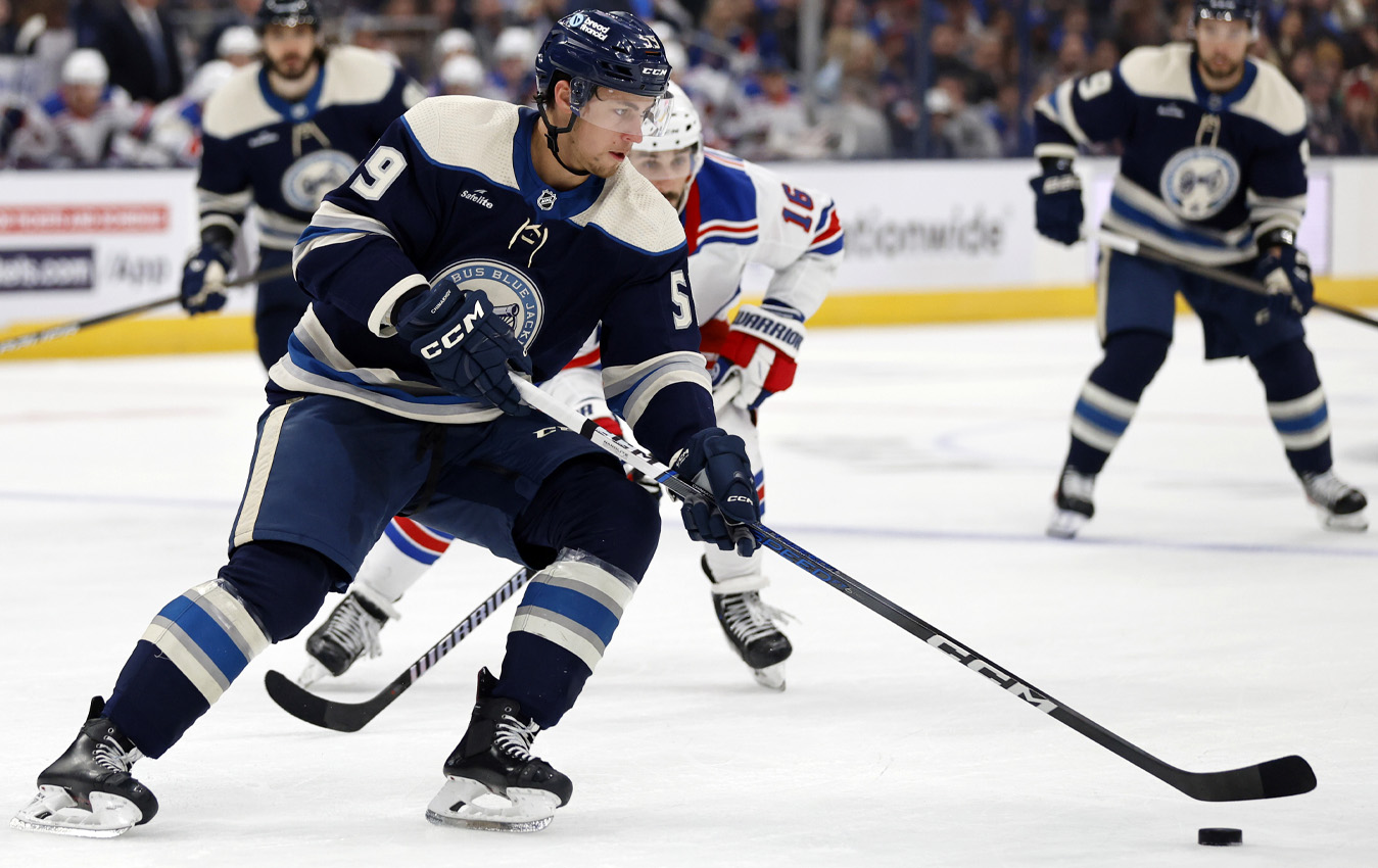 Columbus Blue Jackets forward Yegor Chinakhov, left, controls the puck in front of New York Rangers forward Vincent Trocheck during an NHL hockey game in Columbus, Ohio, Sunday, Feb. 25, 2024. The Blue Jackets won 4-2. (AP Photo/Paul Vernon)
