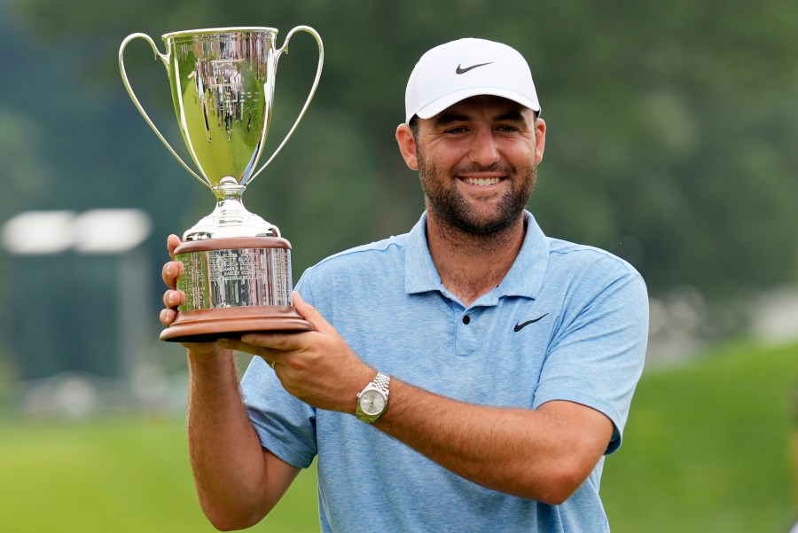 Scottie Scheffler holds up his trophy after winning the Travelers Championship golf tournament at TPC River Highlands, Sunday, June 23, 2024, in Cromwell, Conn. (AP Photo/Seth Wenig)