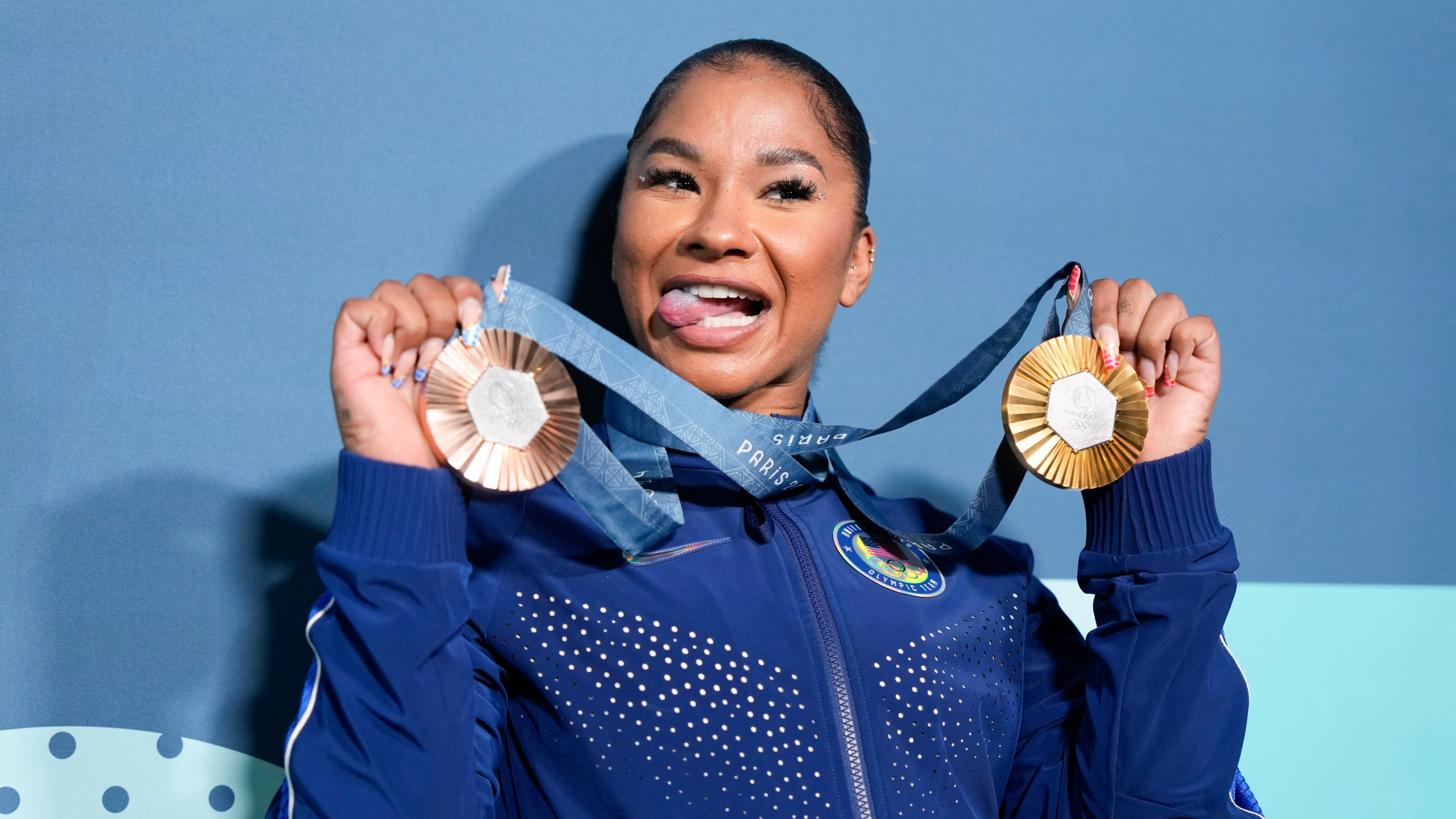 Jordan Chiles, of the United States, holds up her medals after the women's artistic gymnastics individual apparatus finals Bercy Arena at the 2024 Summer Olympics, Monday, Aug. 5, 2024, in Paris, France. (AP Photo/Charlie Riedel)