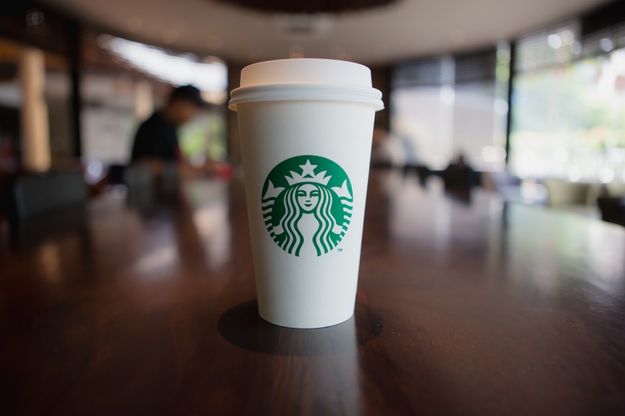 A cup of take home Starbucks Cappuccino coffee on the table in the Starbucks coffee shop. (Adobe Stock)