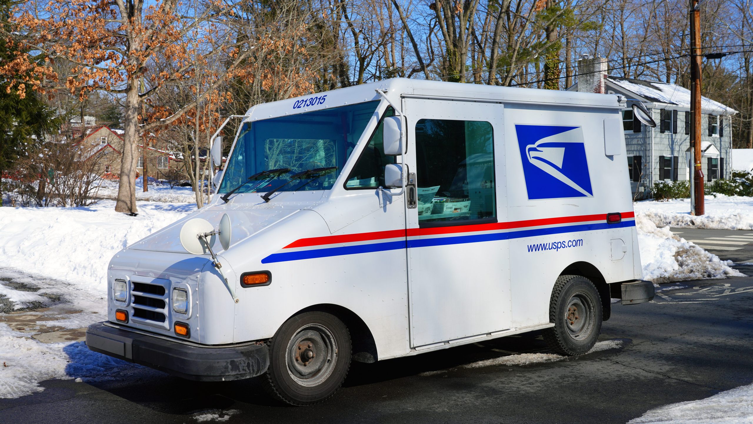 view of a delivery truck from the United States Postal Service (USPS) on the street in New Jersey, United States after a snowfall.