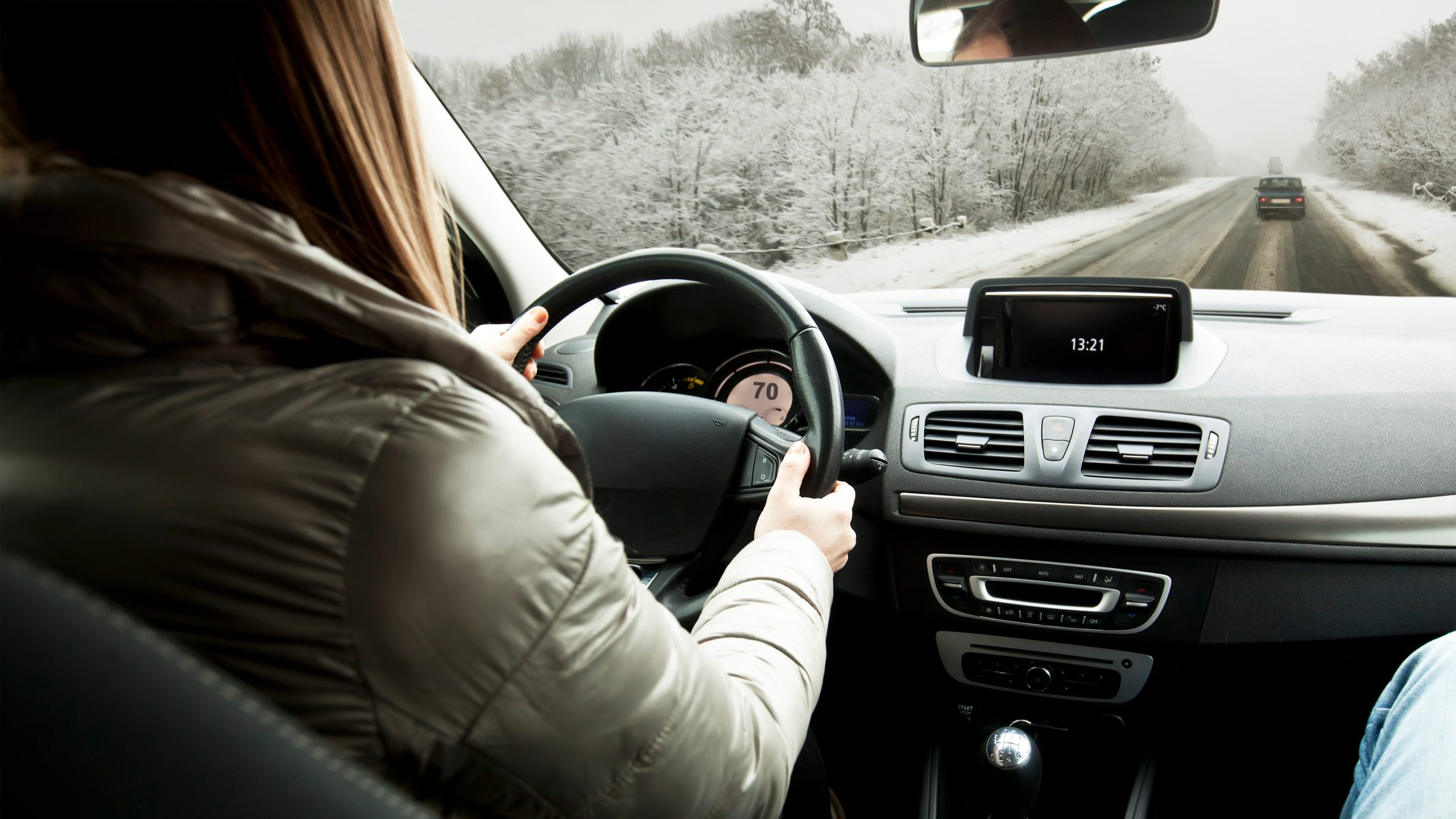 Woman driving the car on snowy road