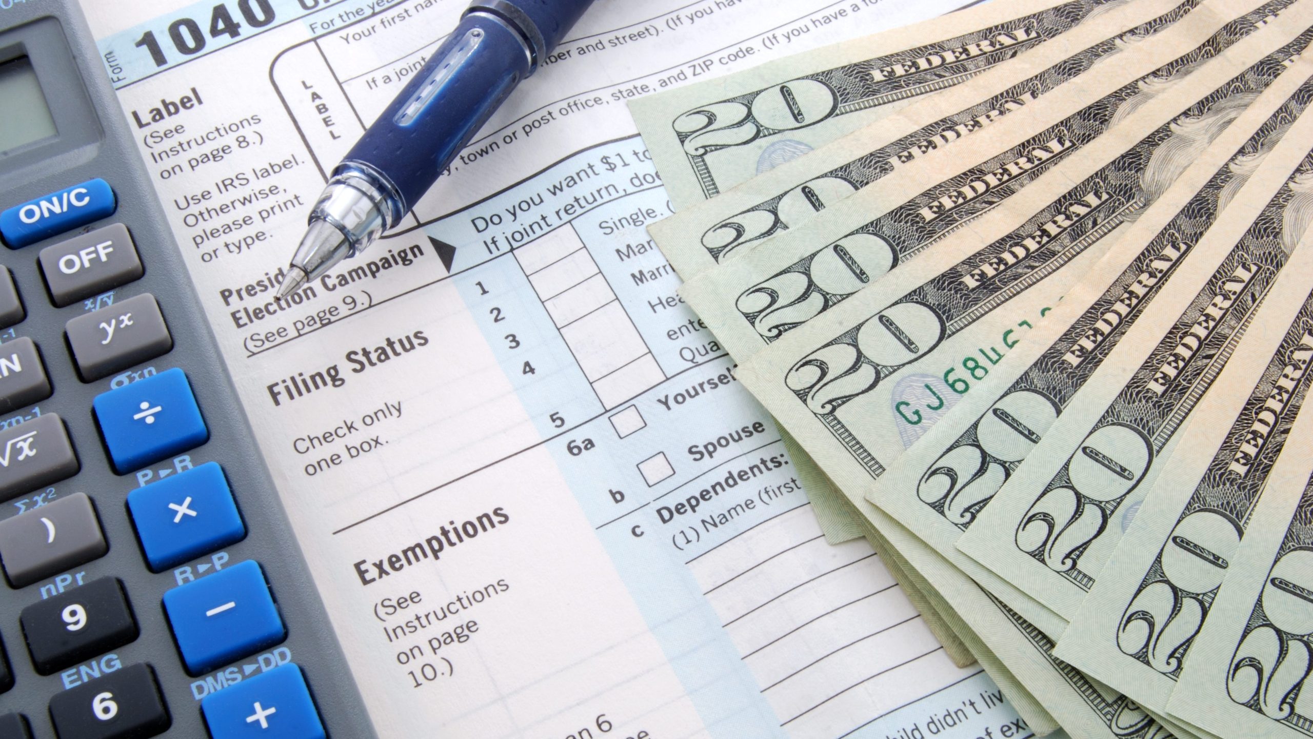 Tax season. calculator, pen on US tax form background