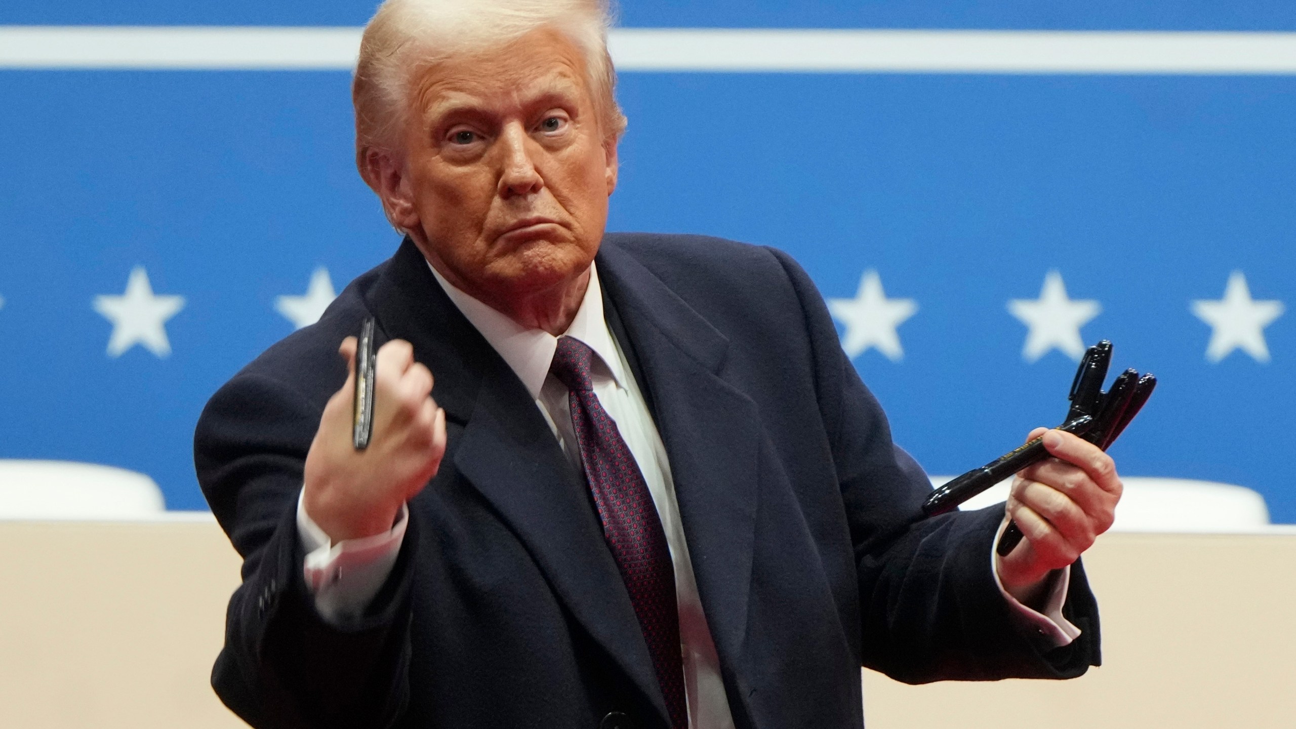 FILE - President Donald Trump throws pens used to sign executive orders to the crowd during an indoor Presidential Inauguration parade event in Washington, Jan. 20, 2025. (AP Photo/Matt Rourke, File)