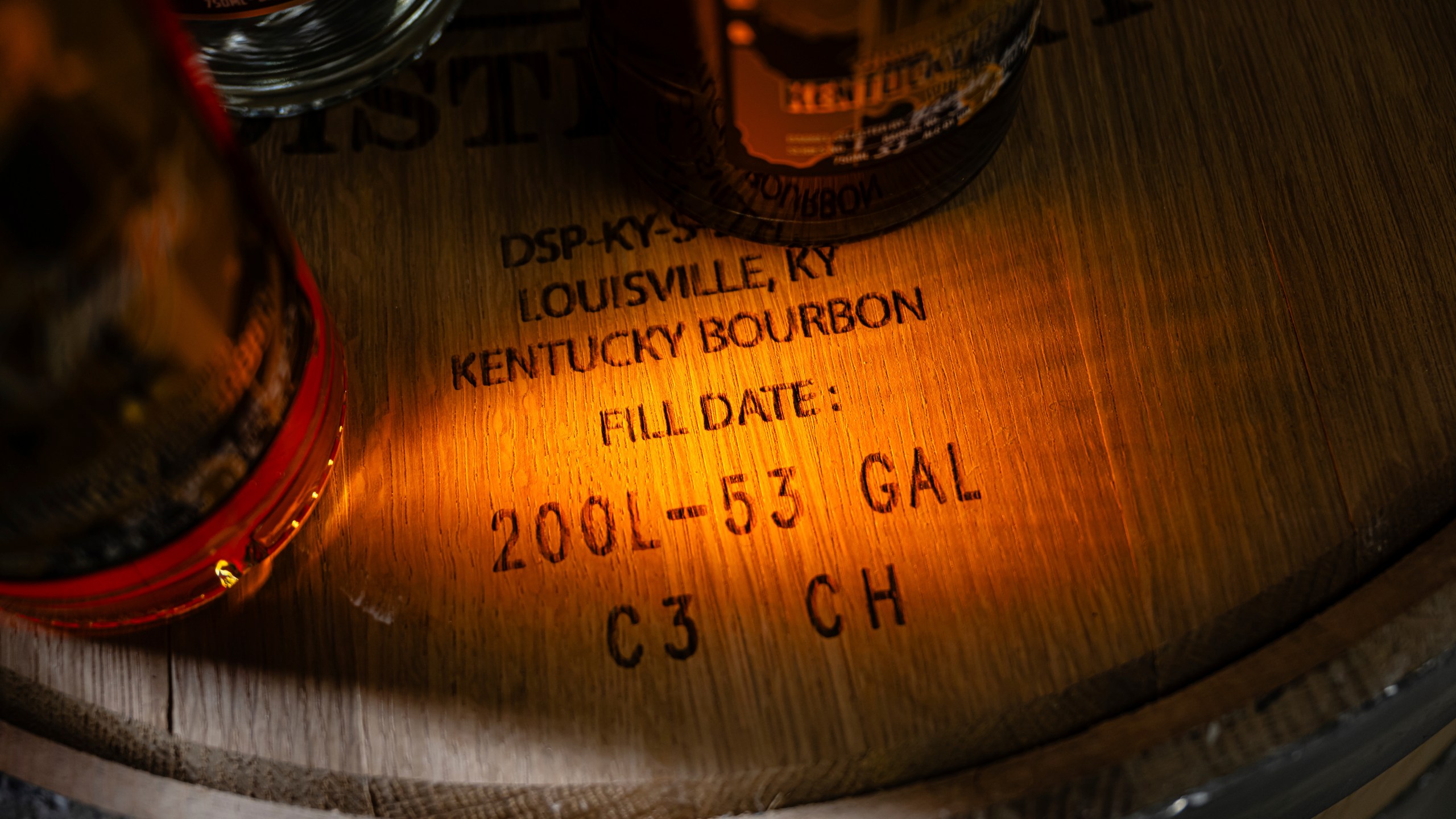 Labeling on the head of a bourbon barrel is seen near bottles of product at the Brough Brothers Distillery which is under construction in Louisville, Ky., Saturday, March 8, 2025. (AP Photo/Jon Cherry)