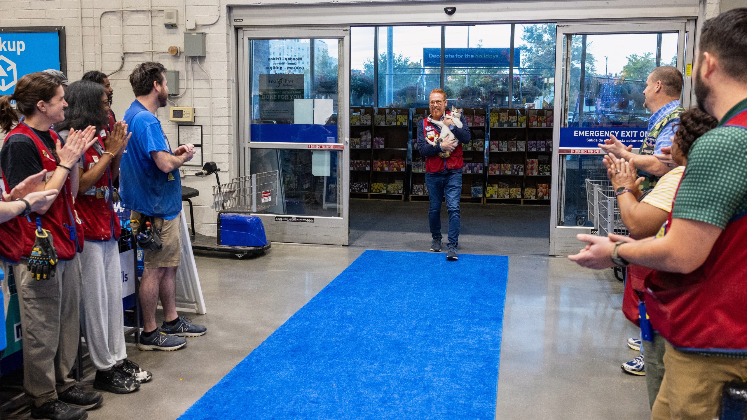In this photo provided by Lowe's, employees welcome back Francine, the store cat, after she disappeared unexpectedly in September, at the Richmond, Va., Lowe's, Tuesday, Oct. 7, 2025. (Kevin Ridley/Lowe's via AP)