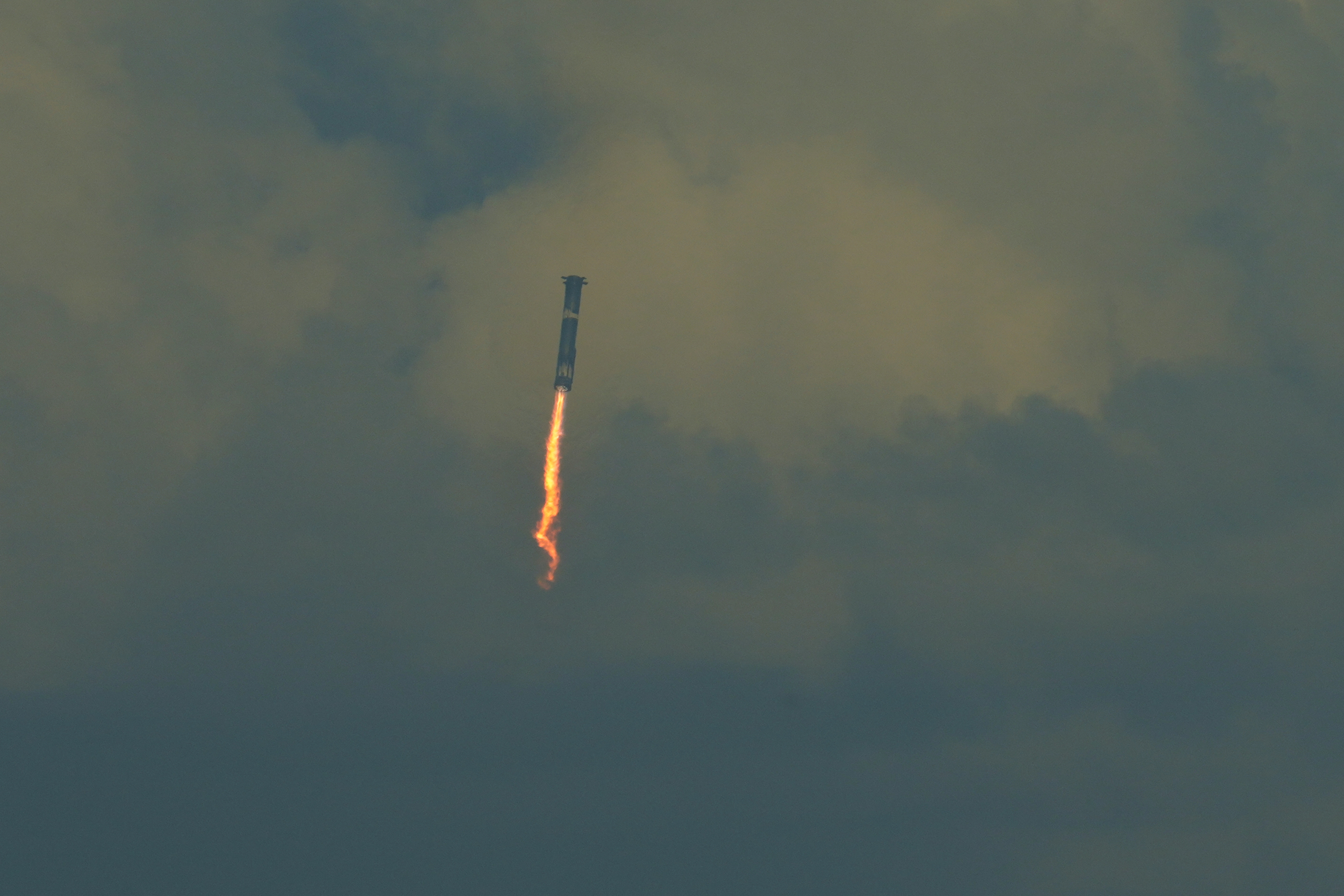 SpaceX's mega rocket booster returns to the gulf during a test flight from Starbase, Texas, Monday, Oct. 13, 2025. (AP Photo/Eric Gay)