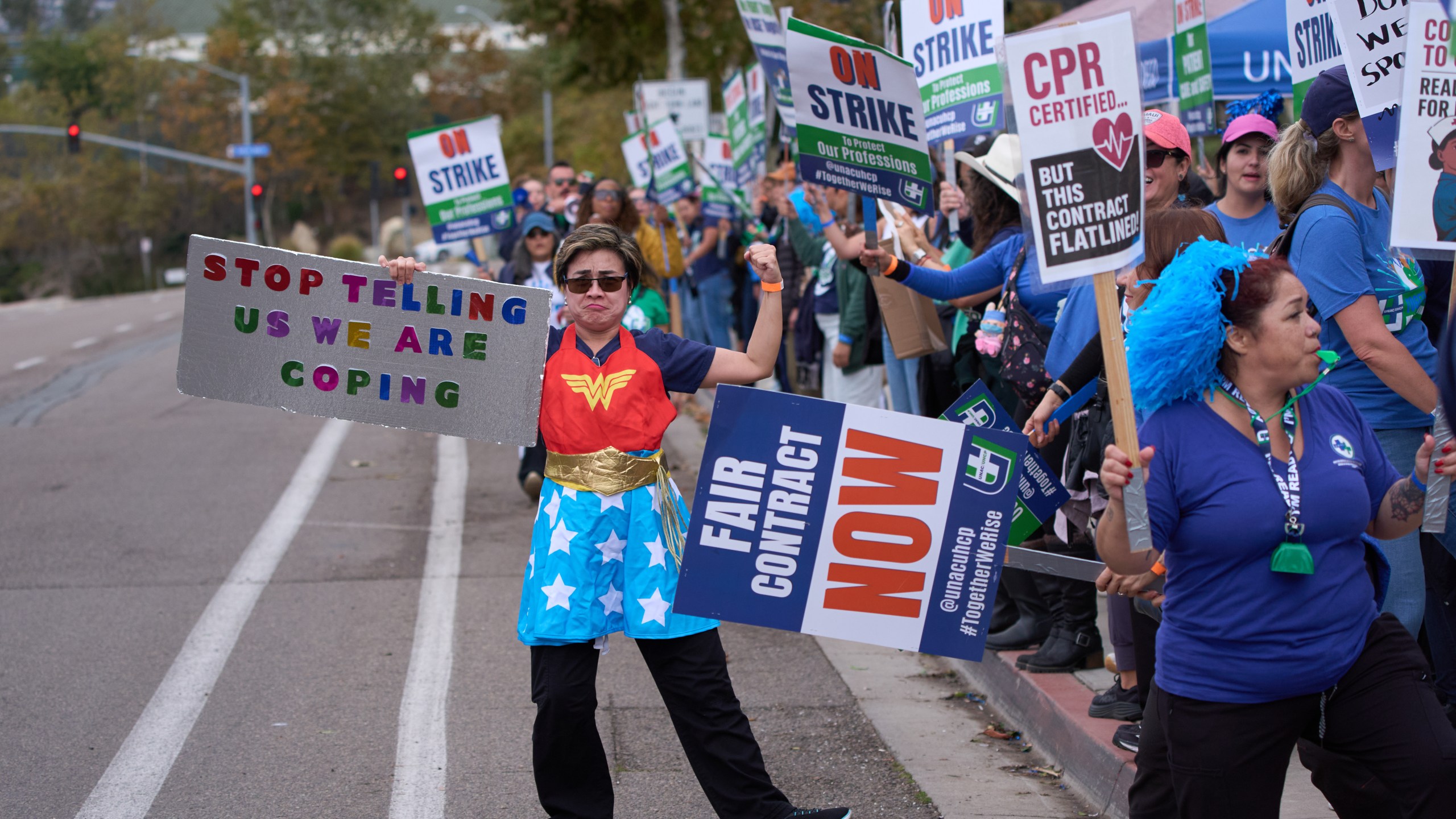 Kaiser Permanente health care workers hold signs and chant slogans while on strike in front of the Kaiser Permanente San Diego Medical Center Tuesday, Oct. 14, 2025, in San Diego. (AP Photo/Gregory Bull)