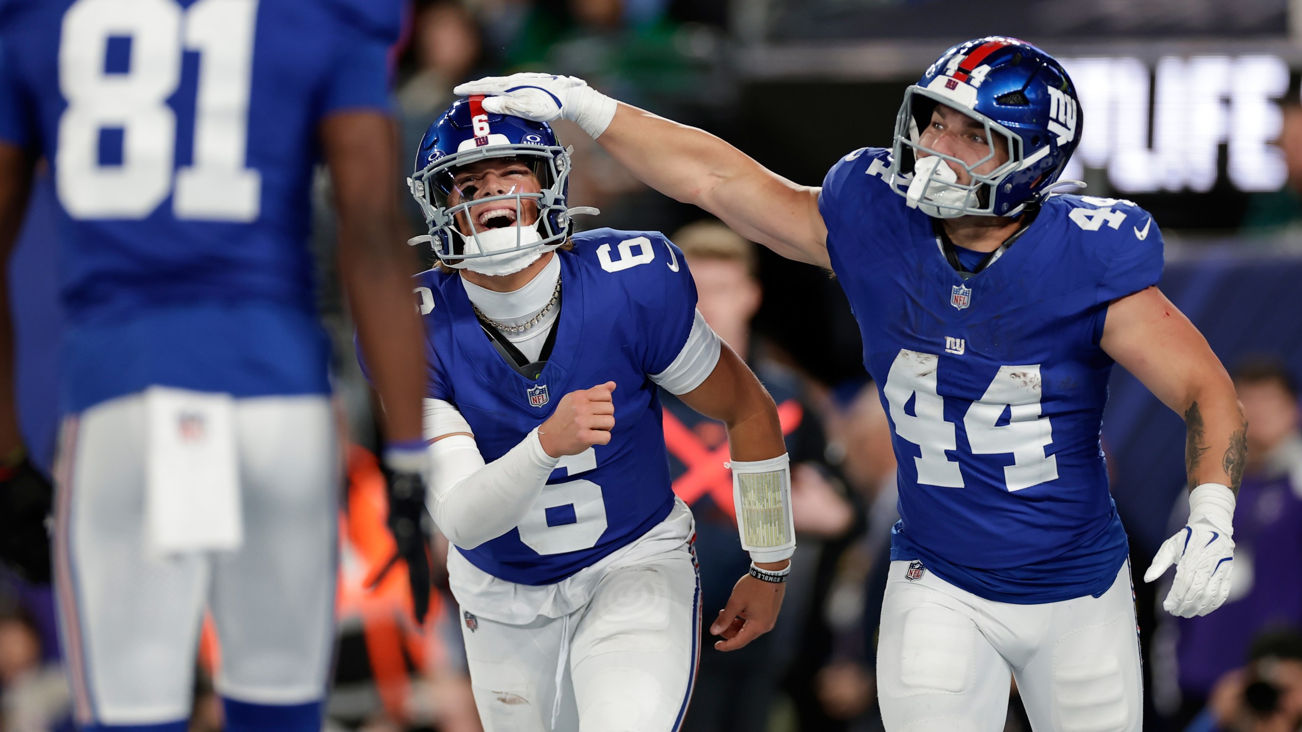 New York Giants' Jaxson Dart, center, and Cam Skattebo celebrate after a touchdown during the first half of an NFL football game against the Philadelphia Eagles Thursday, Oct. 9, 2025, in East Rutherford, N.J. (AP Photo/Adam Hunger)