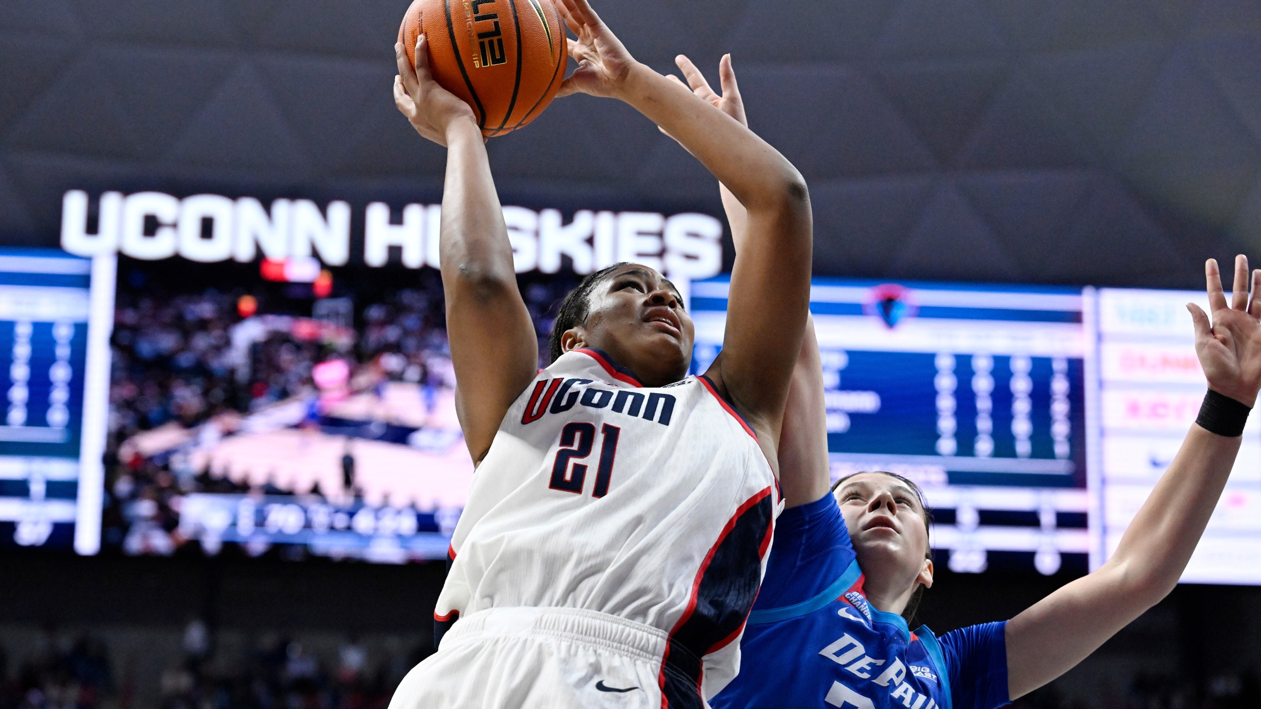 UConn forward Sarah Strong (21) looks to shoot as DePaul guard Kate Novik (33) defends in the second half of an NCAA college basketball game, Sunday, Dec. 7, 2025, in Storrs, Conn. (AP Photo/Jessica Hill)