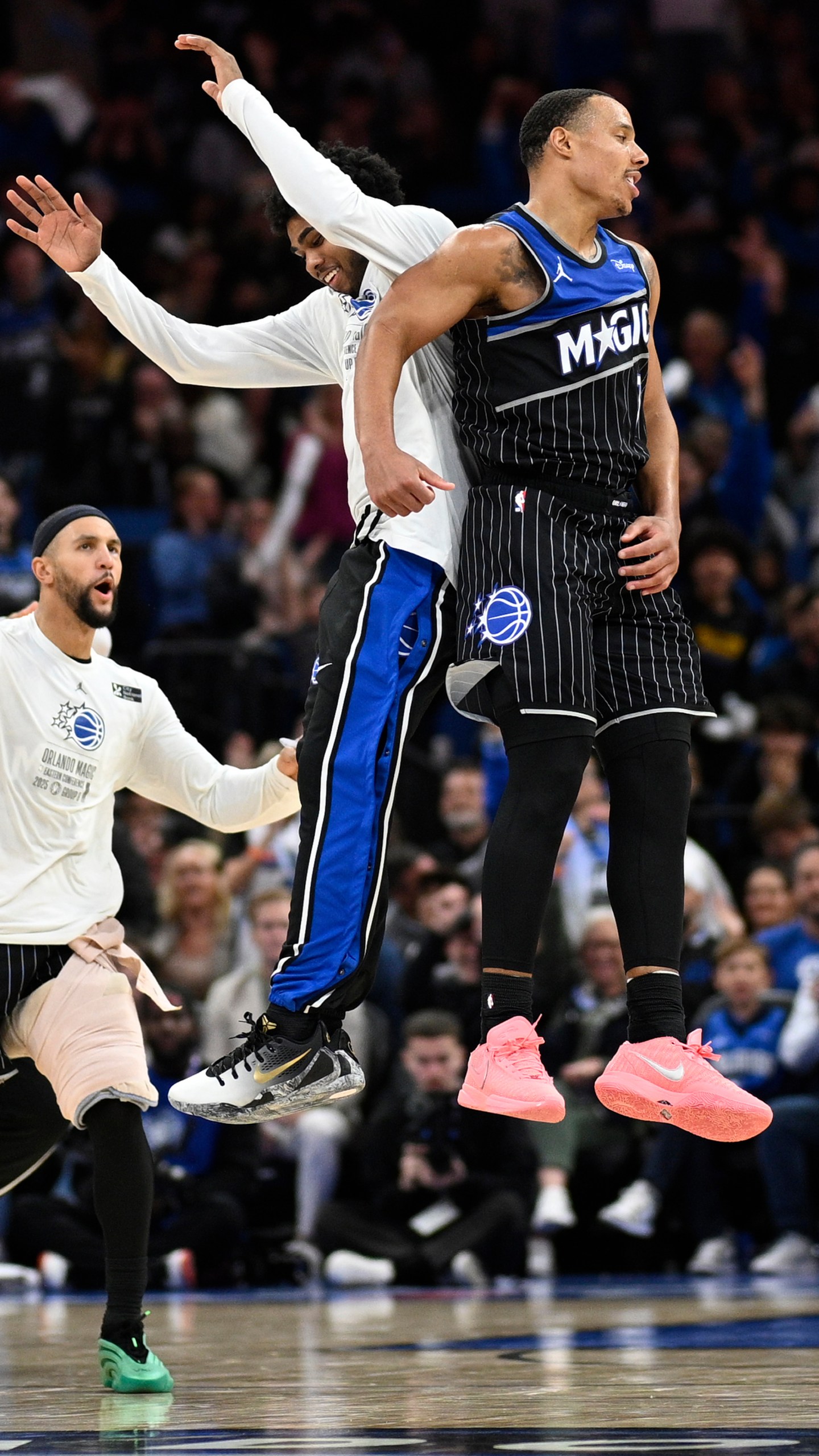 Orlando Magic guard Desmond Bane, right, celebrates with guard Jase Richardson, center, and guard Jalen Suggs, left, after scoring a 3-pointer during the second half of an NBA Cup basketball game against the Miami Heat, Tuesday, Dec. 9, 2025, in Orlando, Fla. (AP Photo/Phelan M. Ebenhack)