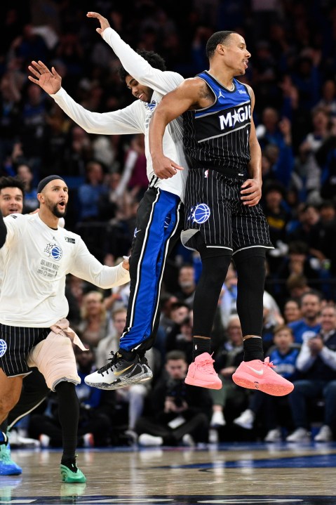 Orlando Magic guard Desmond Bane, right, celebrates with guard Jase Richardson, center, and guard Jalen Suggs, left, after scoring a 3-pointer during the second half of an NBA Cup basketball game against the Miami Heat, Tuesday, Dec. 9, 2025, in Orlando, Fla. (AP Photo/Phelan M. Ebenhack)