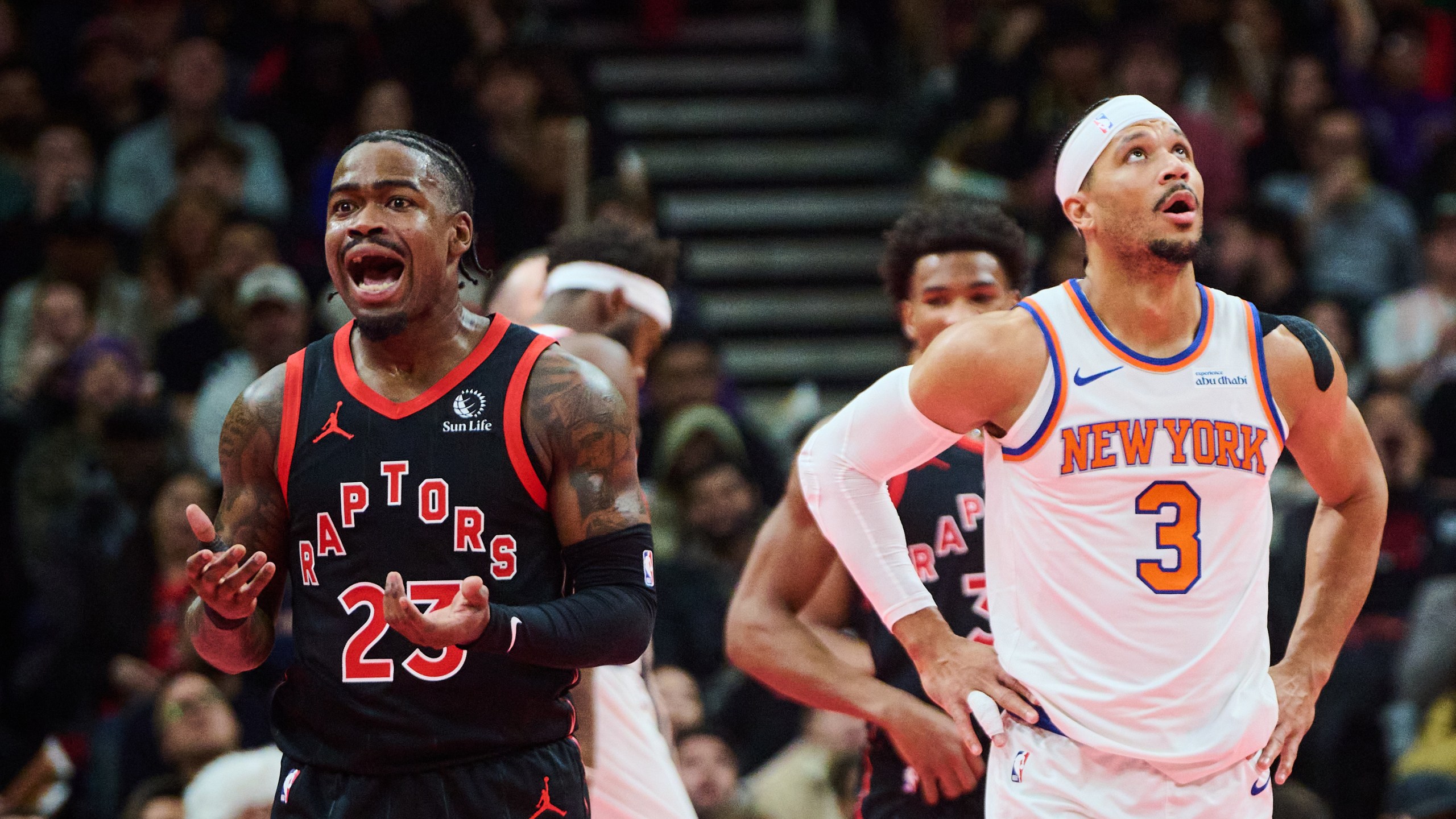 Toronto Raptors' Jamal Shead, left, and New York Knicks' Josh Hart (3) react to a call during the first half of an NBA Cup basketball game in Toronto, Tuesday, Dec. 9, 2025. (Sammy Kogan/The Canadian Press via AP)