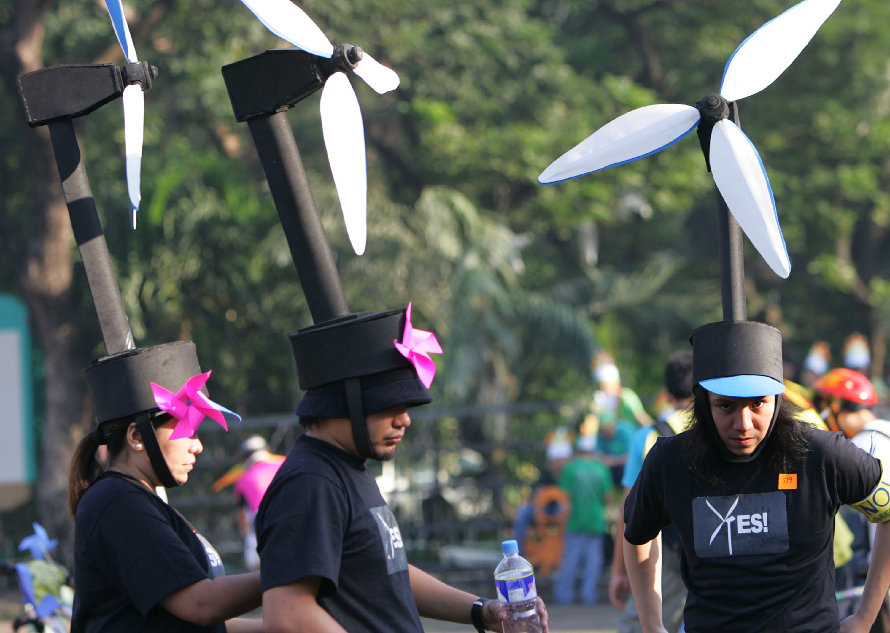 FILE -Participants wear wind turbine headgear to raise peoples awareness on renewable energy, fix their costumes during the Global Day of Action Against Climate Change ,Dec. 8, 2007 in suburban Quezon City, north of Manila, Philippines. (AP Photo/Pat Roque, File)