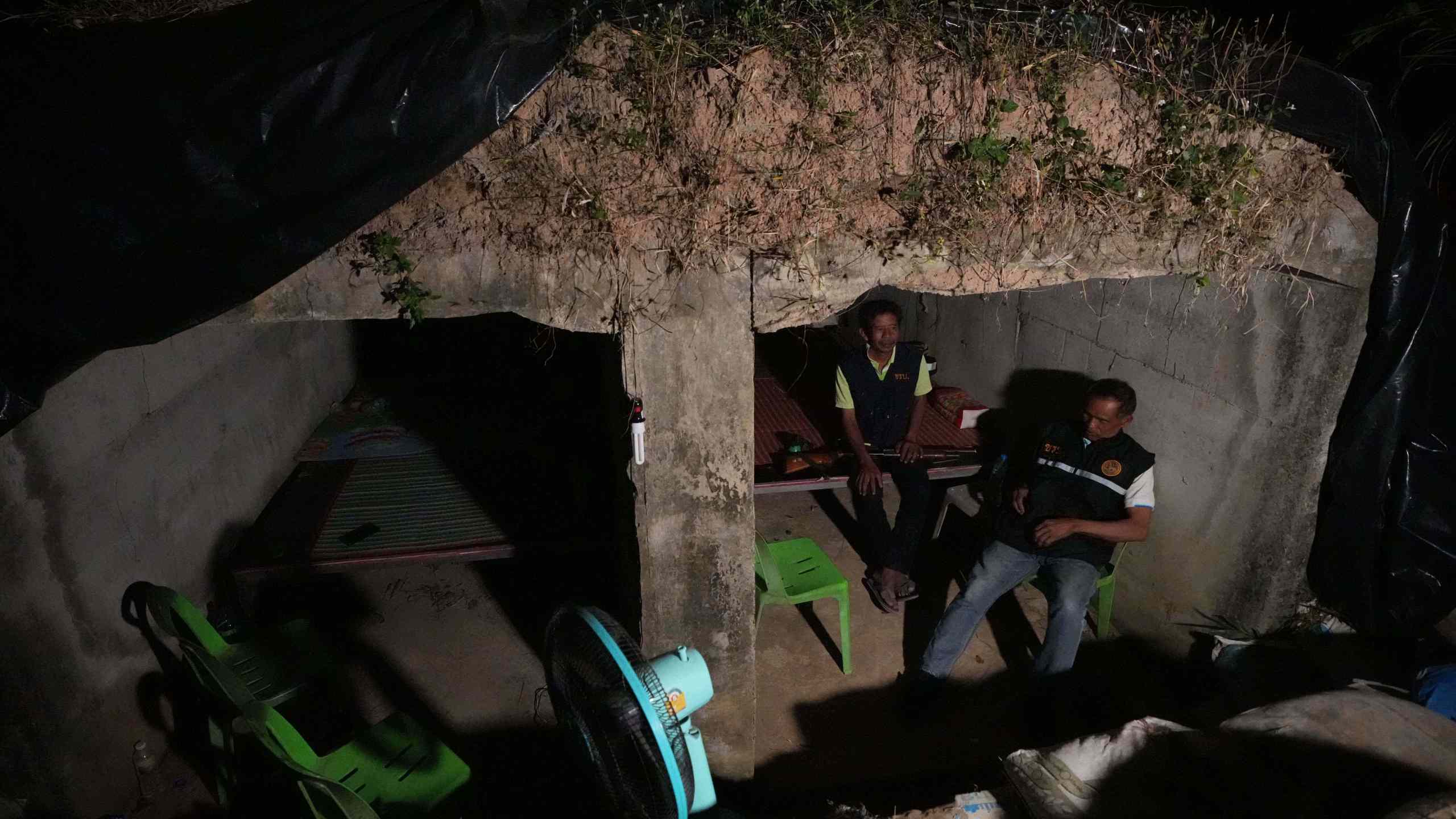 Village security volunteers sit inside shelter during Thai and Cambodian soldiers clashes in Surin province, Thailand, Tuesday, Dec. 9, 2025. (AP Photo/Sakchai Lalit)