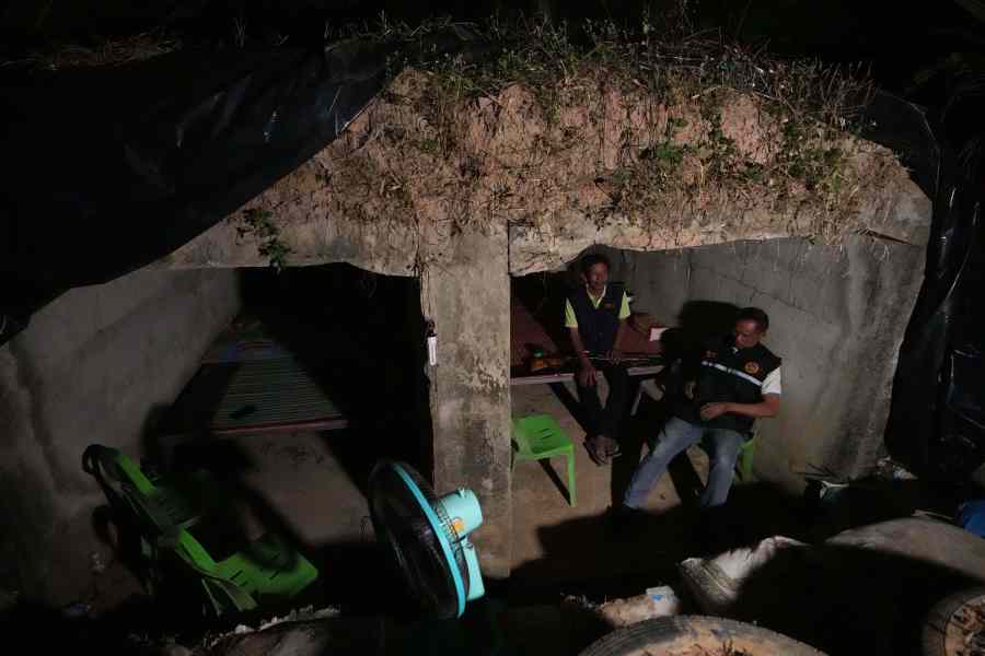 Village security volunteers sit inside shelter during Thai and Cambodian soldiers clashes in Surin province, Thailand, Tuesday, Dec. 9, 2025. (AP Photo/Sakchai Lalit)
