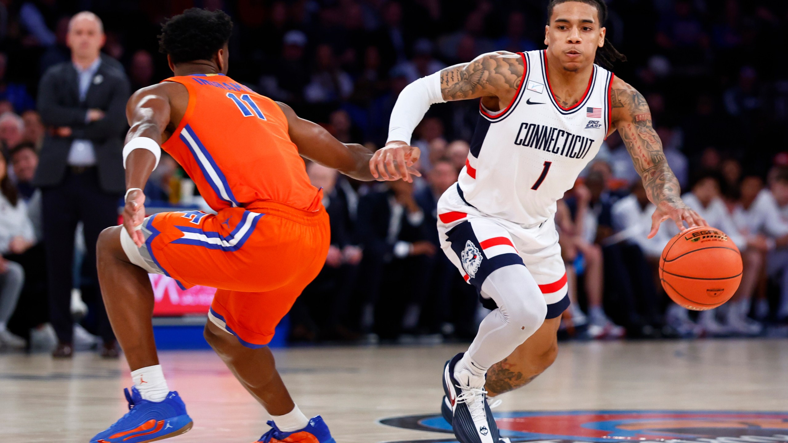 UConn guard Solo Ball (1) drives to the basket against Florida guard CJ Ingram II (11) during the first half of an NCAA basketball game, Tuesday, Dec. 9, 2025, in New York. (AP Photo/Noah K. Murray)