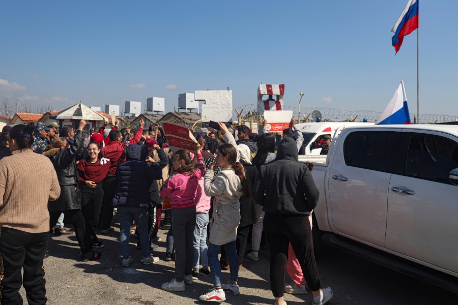 FILE - Members of the Alawite minority gather outside the Russian air base in Hmeimim, near Latakia in Syria's coastal region, March 11, 2025, as they seek refuge there after recent violence and retaliatory killings in the area. (AP Photo/Omar Albam, File)