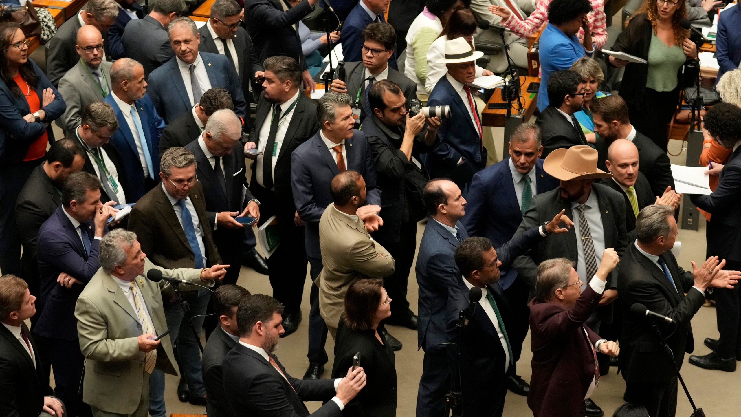 Congresspeople from parties supporting former President Jair Bolsonaro, sentenced for leading a coup attempt, attend a session to consider a bill to alter sentencing guidelines for certain crimes including coups d'état, in Brasilia, Brazil, Tuesday, Dec. 9, 2025. (AP Photo/Eraldo Peres)