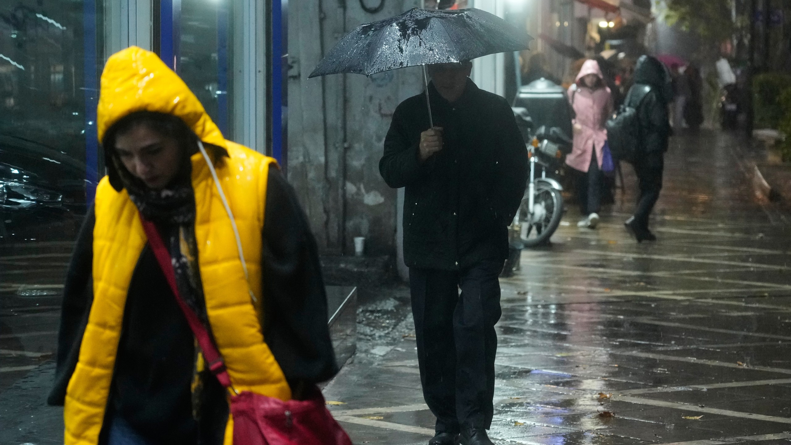 A man walks with an umbrella under a rain in Tehran, Iran, Wednesday, Dec. 10, 2025. (AP Photo/Vahid Salemi)
