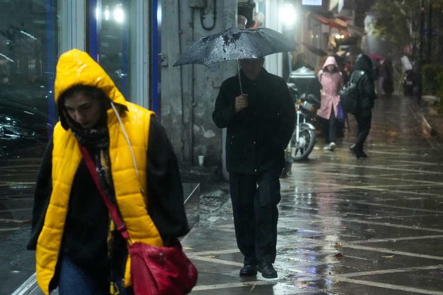 A man walks with an umbrella under a rain in Tehran, Iran, Wednesday, Dec. 10, 2025. (AP Photo/Vahid Salemi)