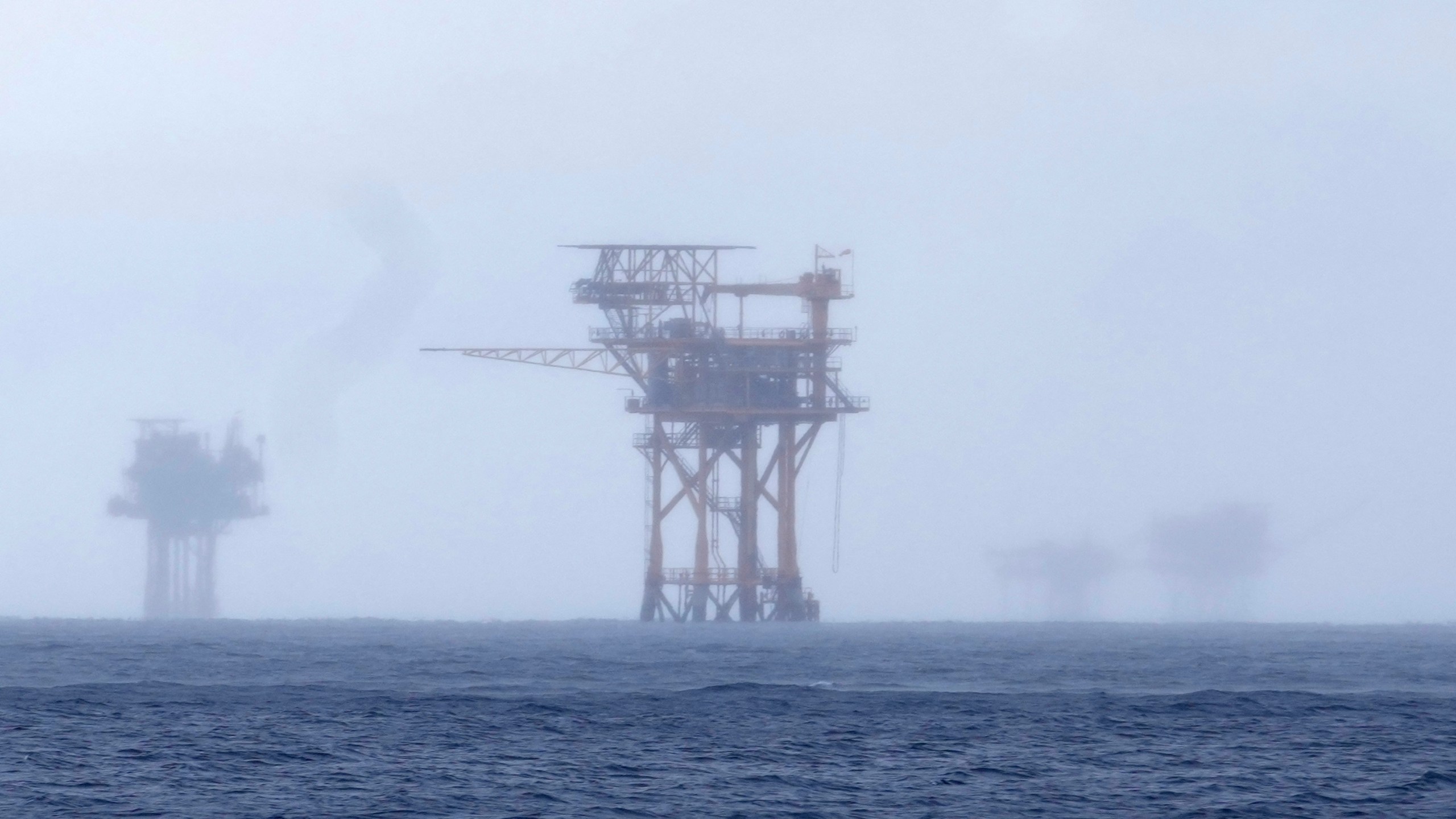 FILE - Oil platforms are visible through the haze near the Flower Garden Banks National Marine Sanctuary in the Gulf of Mexico, off the coast of Galveston, Texas, Saturday, Sept. 16, 2023. (AP Photo/LM Otero, File)