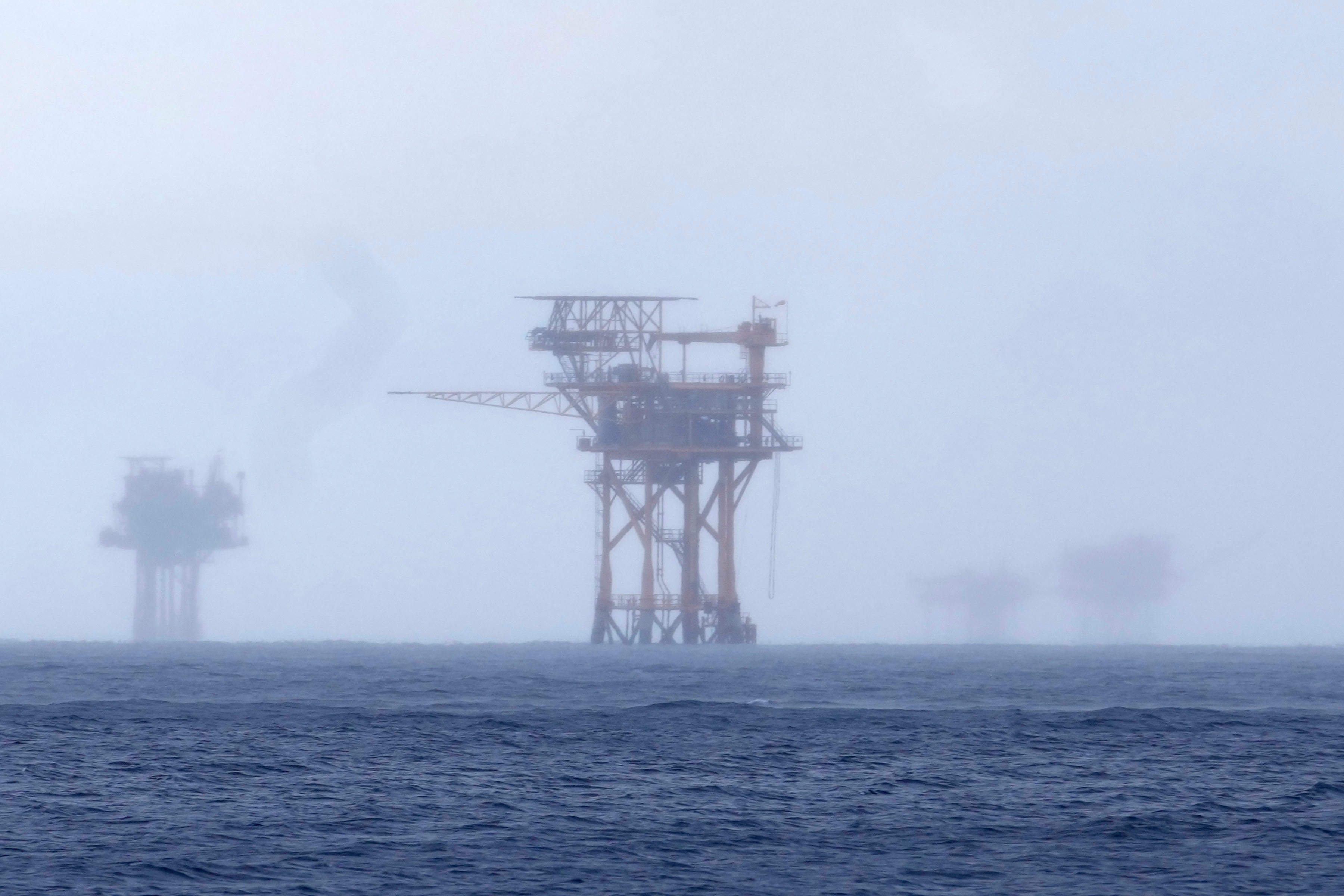 FILE - Oil platforms are visible through the haze near the Flower Garden Banks National Marine Sanctuary in the Gulf of Mexico, off the coast of Galveston, Texas, Saturday, Sept. 16, 2023. (AP Photo/LM Otero, File)