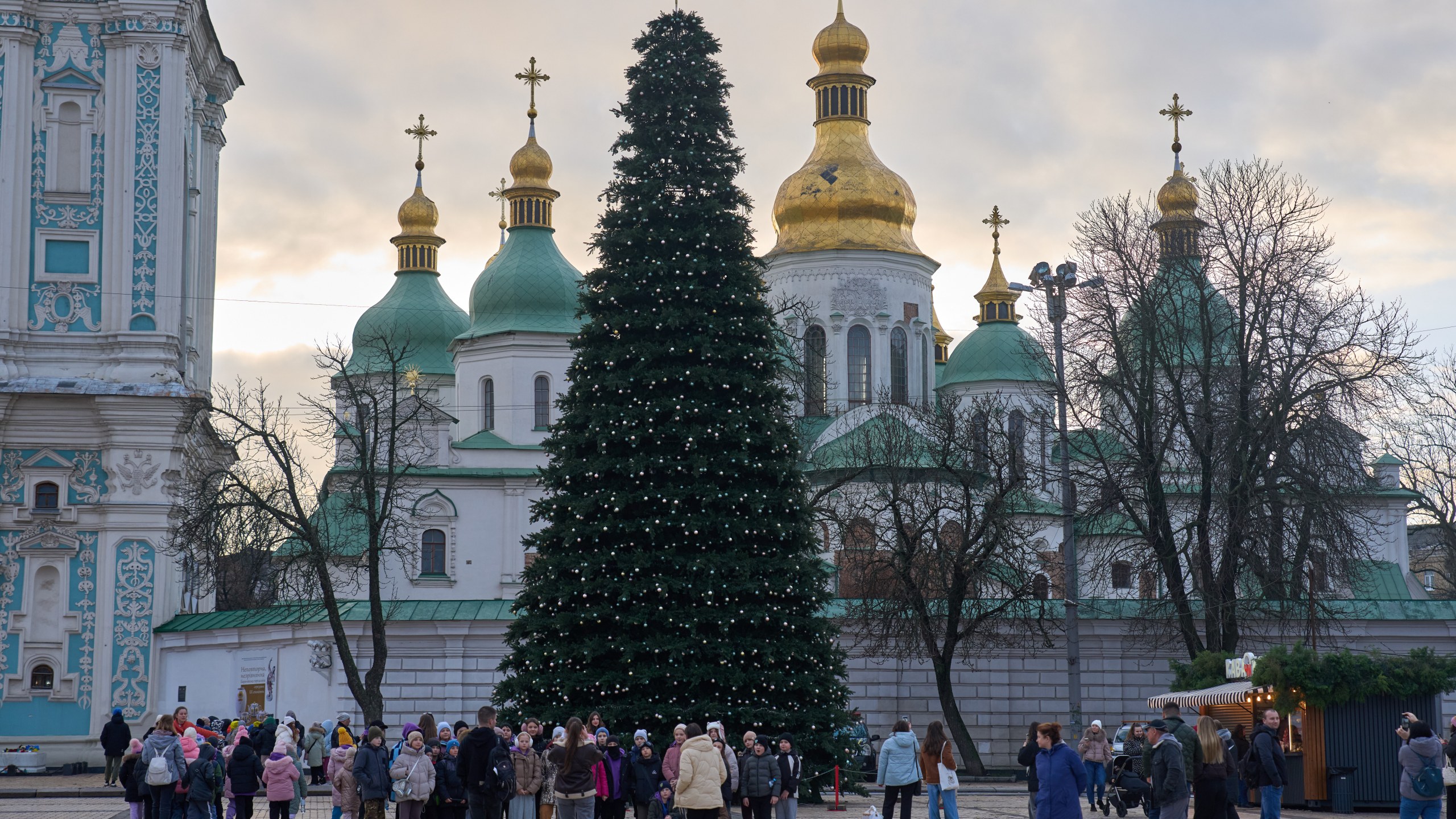 People walk around the Christmas tree in front of St. Sophia Monastery in central Kyiv, Ukraine, Wednesday, Dec. 10, 2025. (AP Photo/Efrem Lukatsky)