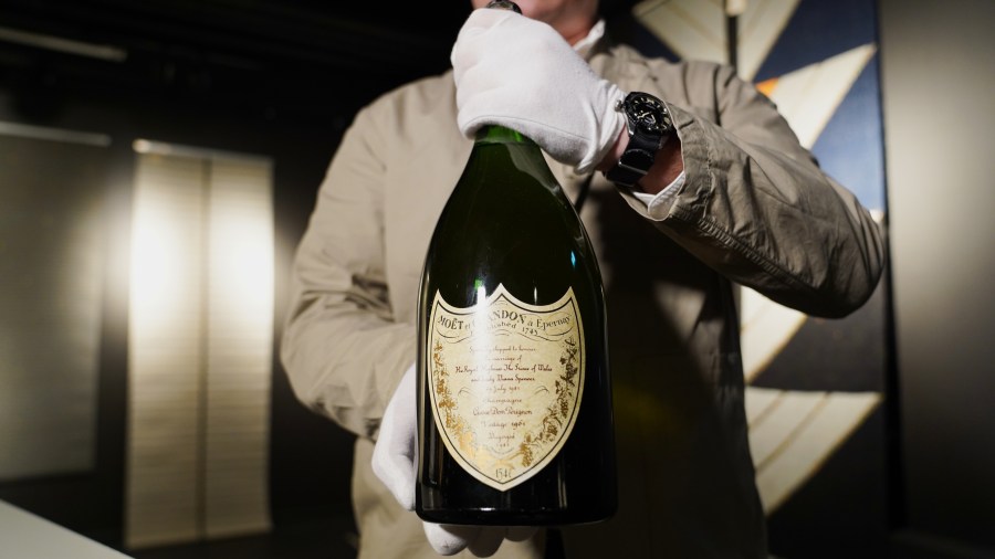 Thomas Rosendahl, head of wine department of Bruun Rasmussen auction house, holds a bottle of Dom Perignon Vintage 1961 champagne, specially produced for wedding of The Prince of Wales and Lady Diana in 1981, in Lyngby, Denmark, Wednesday, Dec. 3, 2025. (AP Photo/James Brooks)